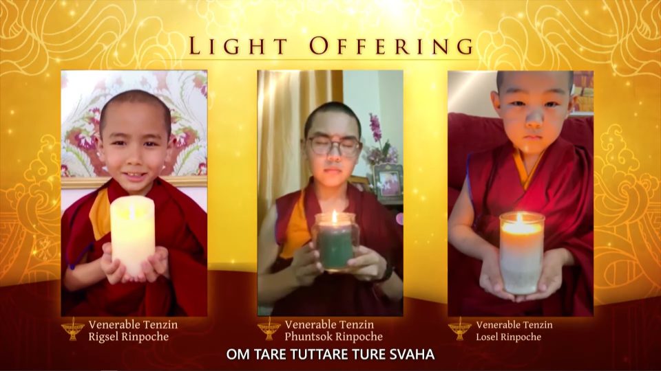 Image of three young rinpoches holding candles and making light offerings