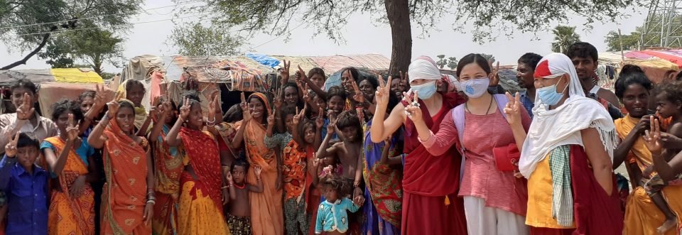 Large group of villagers with in face masks two nuns and a volunteer dressed in lay clothes.