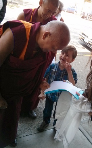 Lama Zopa Rinpoche being offered the hand-traced Heart Sutra by Dechen Bloom, Portland, Oregon, US, April 2014. Photo by Mandala.